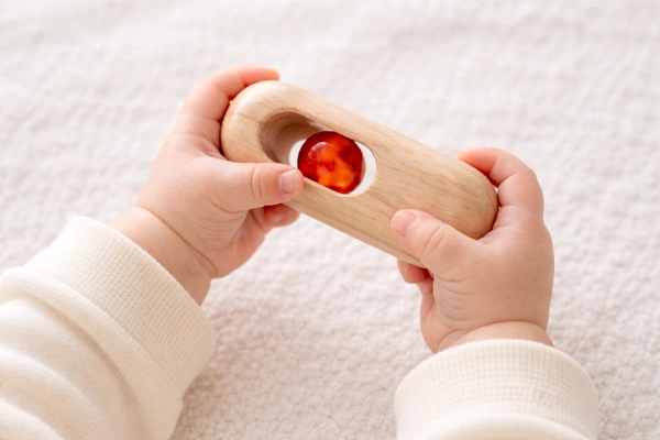 ベビーラトルを触る赤ちゃんの手